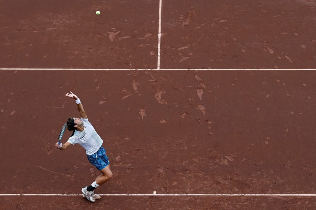 Tenista argentino compitiendo en un torneo sobre polvo de ladrillo
